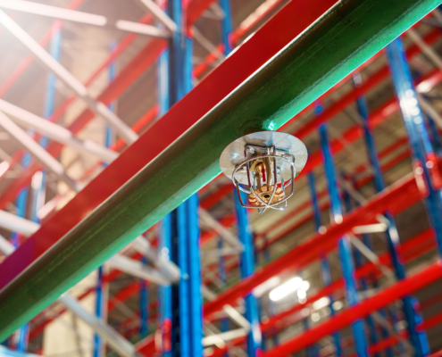 Fire sprinkler in a large warehouse with metal shelving